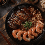 Overhead view of a steaming plate of Hokkien Noodles with shrimp, pork, and vegetables, showcasing the rich, dark sauce and smoky wok hei.