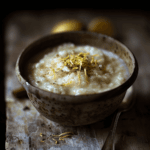 A bowl of creamy rice pudding garnished with cinnamon and lemon zest