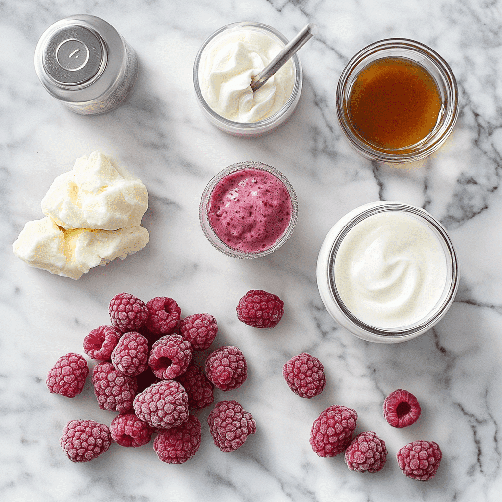 Ingredients for raspberry smoothie including frozen raspberries, yogurt, almond milk, and maple syrup