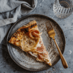 A delicious slice of Pizza Rustica with a golden-brown crust, showcasing the layers of cheese and cured meats.
