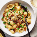 Pasta with bacon and peas in a bowl