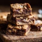 Sliced Brown Butter Nutella Stuffed Cookie Bars showing gooey center on a wooden board.