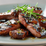 Juicy grilled steak strips coated in honey glaze with caramelized edges and visible grill marks on a modern plate