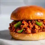 Cajun chicken sloppy joes on a toasted brioche bun with green onion garnish