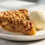 A slice of impossible apple pie on a plate with a golden crust.